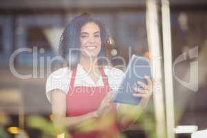 Smiling waitress using a digital tablet