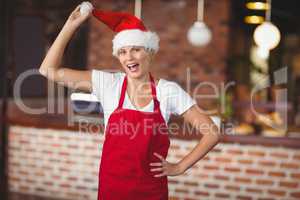 Pretty waitress touching her santa hat