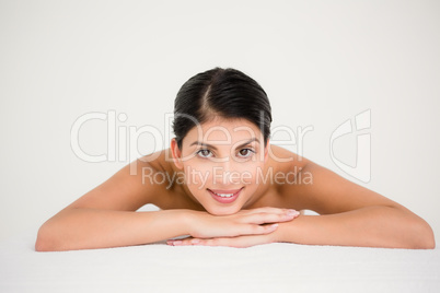 Pretty brunette enjoying a massage smiling at camera