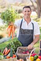 Smiling farmer handing a bunch of carrots