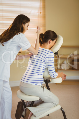 Young woman getting massage in chair