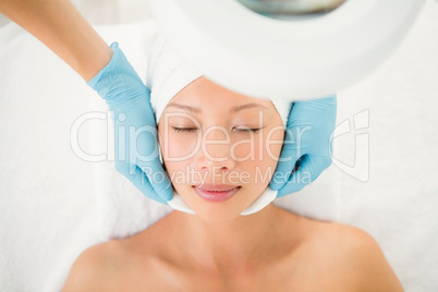 Hands cleaning woman face with cotton swabs