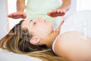 Close up view of relaxed pregnant woman getting reiki treatment