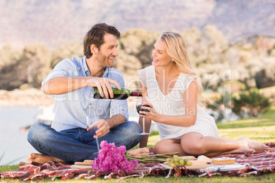 Cute couple on date pouring red wine