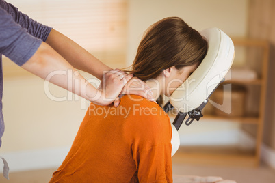 Young woman getting massage in chair