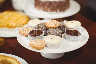 Close up plates of pastries and cupcakes