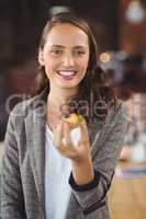 Smiling young woman showing muffin