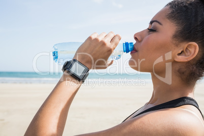 Fit woman drinking water from bottle