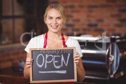 Pretty waitress with a chalkboard open sign