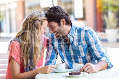 Cute couple sitting at a cafe head to head
