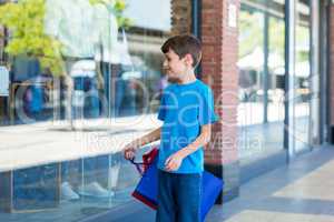 Young boy playing with shopping bags