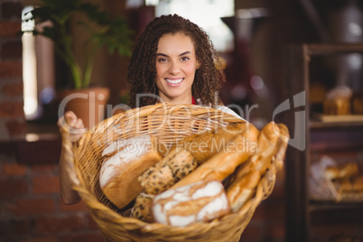 Smiling waitress showing a basket of bread