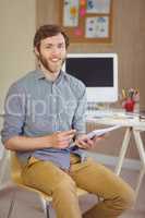 Bearded hipster smiling at camera holding notes
