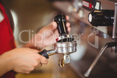 Close up of a barista pressing coffee