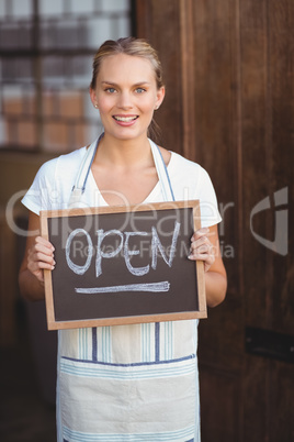 Pretty waitress with a chalkboard open sign