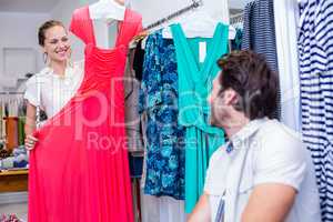 Smiling woman showing red dress to boyfriend
