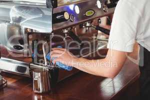Barista cleaning coffee machine