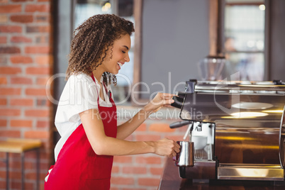 Smiling barista preparing a coffee