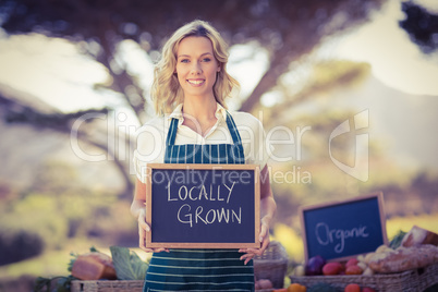Smiling farmer woman holding a locally grown sign