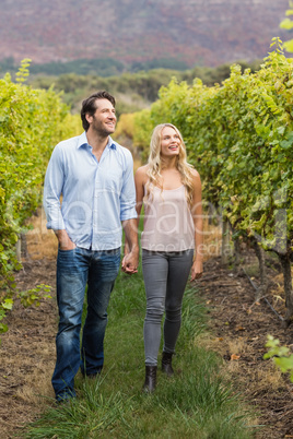 Young happy couple walking side by side while holding hands