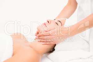 Attractive woman receiving facial massage at spa center