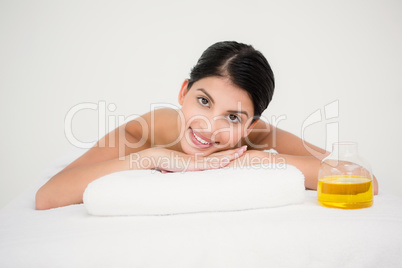 Pretty brunette enjoying a massage smiling at camera