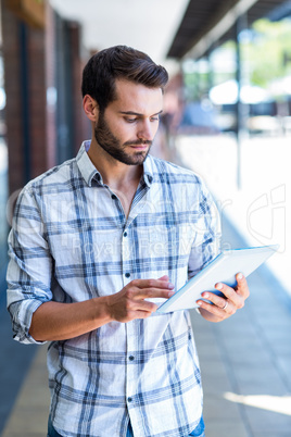 Hipster man using tablet computer in the city