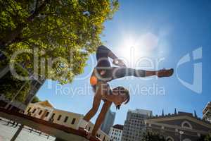 Athletic woman performing handstand on bench