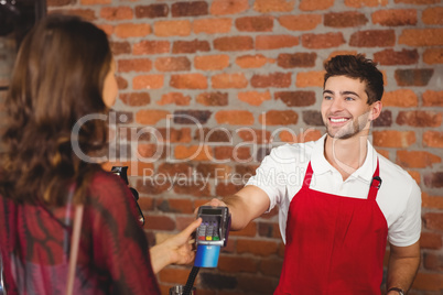 Smiling waiter handing a pin terminal