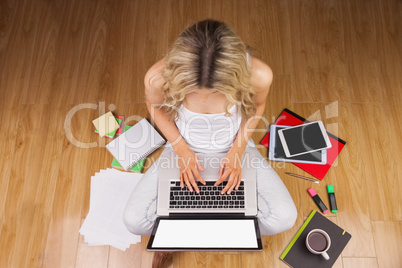 Overhead shot of woman, coffee, laptop, and tablet