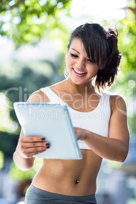 Smiling athletic woman using tablet computer