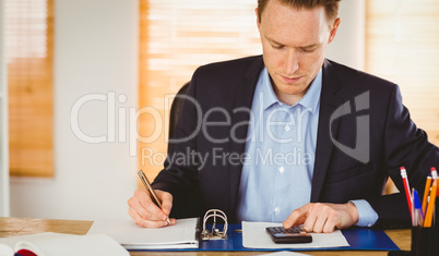 Concentrated businessman writing down