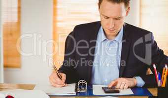 Concentrated businessman writing down