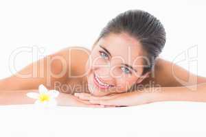 A portrait smiling pretty brunette on massage table