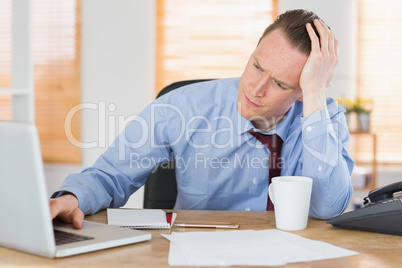 Stressed businessman working at his desk