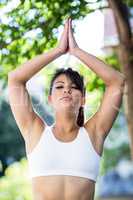 Peaceful athletic woman doing yoga with eyes closed