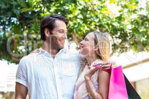 Smiling couple with shopping bags embracing