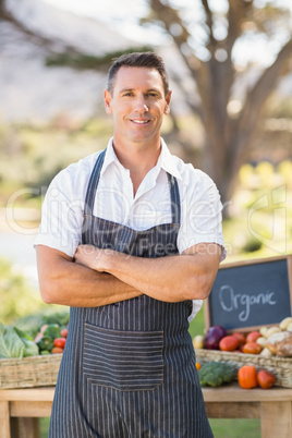 Smiling farmer standing with arms crossed