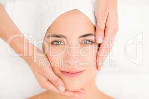 Attractive woman receiving facial massage at spa center