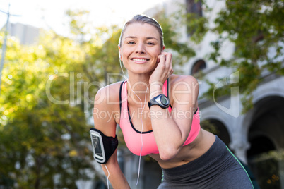 A beautiful athlete putting her headphones