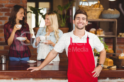 Handsome waiter leaning on the counter