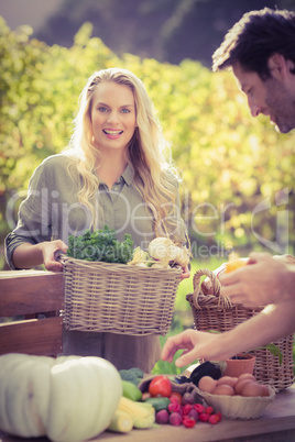 Smiling blonde customer buying vegetables