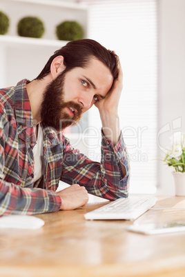 Hipster businessman stressed at his desk