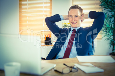 Relaxed businessman sitting back at desk