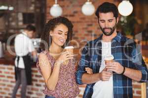 Smiling hipster couple with take-away cups
