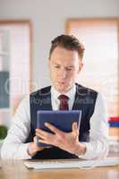 Focused businessman using his tablet pc