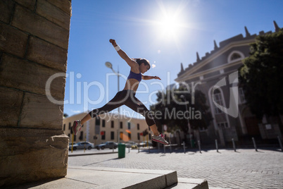 Athletic woman jumping off the stairs