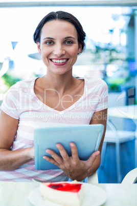 Happy woman enjoys using her tablet