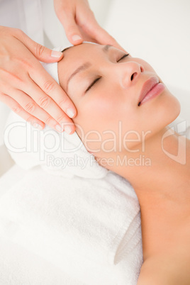 Attractive young woman receiving forehead massage