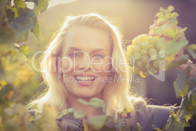 Young happy woman holding grapes